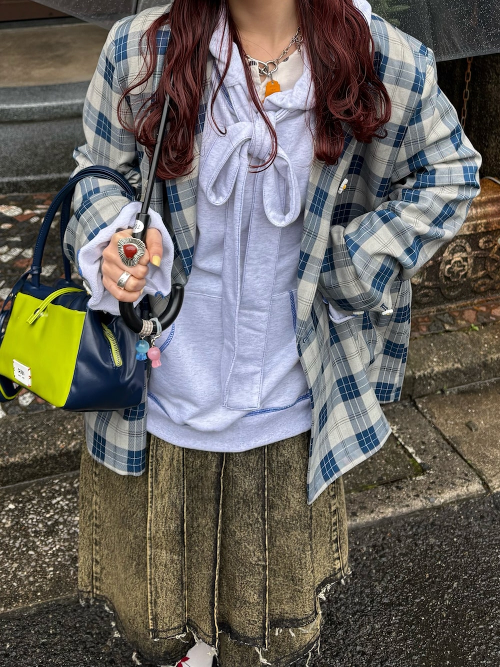 ブルー系のテーラードジャケット、グレー系のパーカー、イエロー系のデニムパンツを着用したレディースの春コーディネートの2枚目の写真