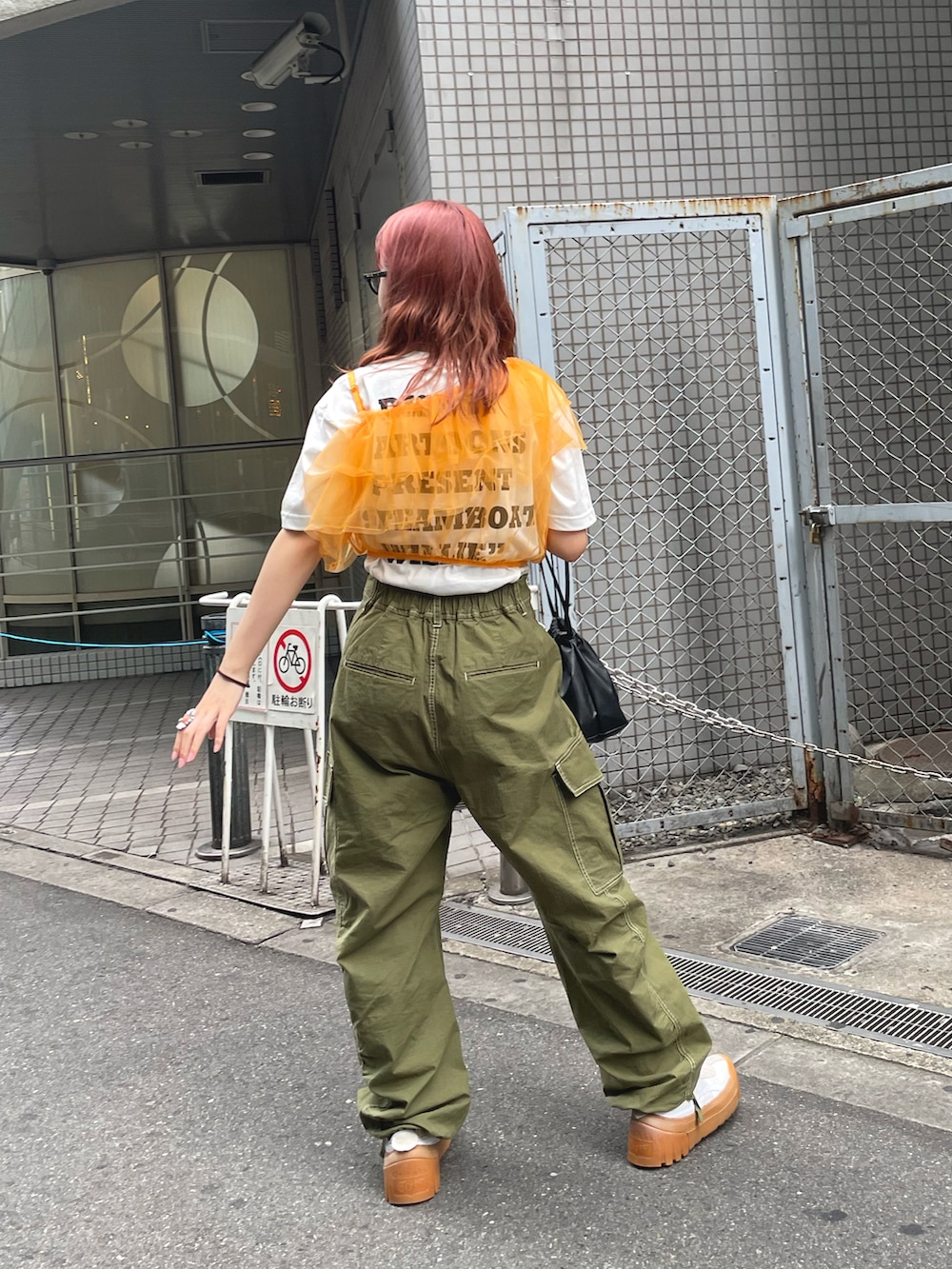「夏コーデ、Tシャツ、白Tシャツ、オレンジ、オレンジコーデ、カラーコーデ、チュール、ビスチェ、カーゴパンツ、カーキ、巾着バッグ、ディズニーコーデ、レイヤードスタイル」|「CIAOPANICのワンショルダーチュールビスチェ(その他トップス、オレンジ系)」を使った、丸尾佳奈さん(レディース・158cm)の夏コーディネートの3枚目の写真