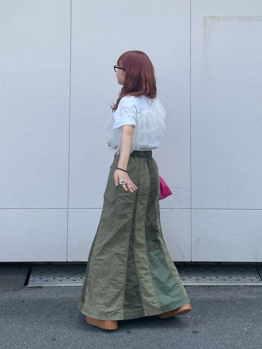 ピンク系のショルダーバッグ、グリーン系のスカート、ホワイト系のその他トップスを着用したレディースの夏コーディネートの3枚目の写真