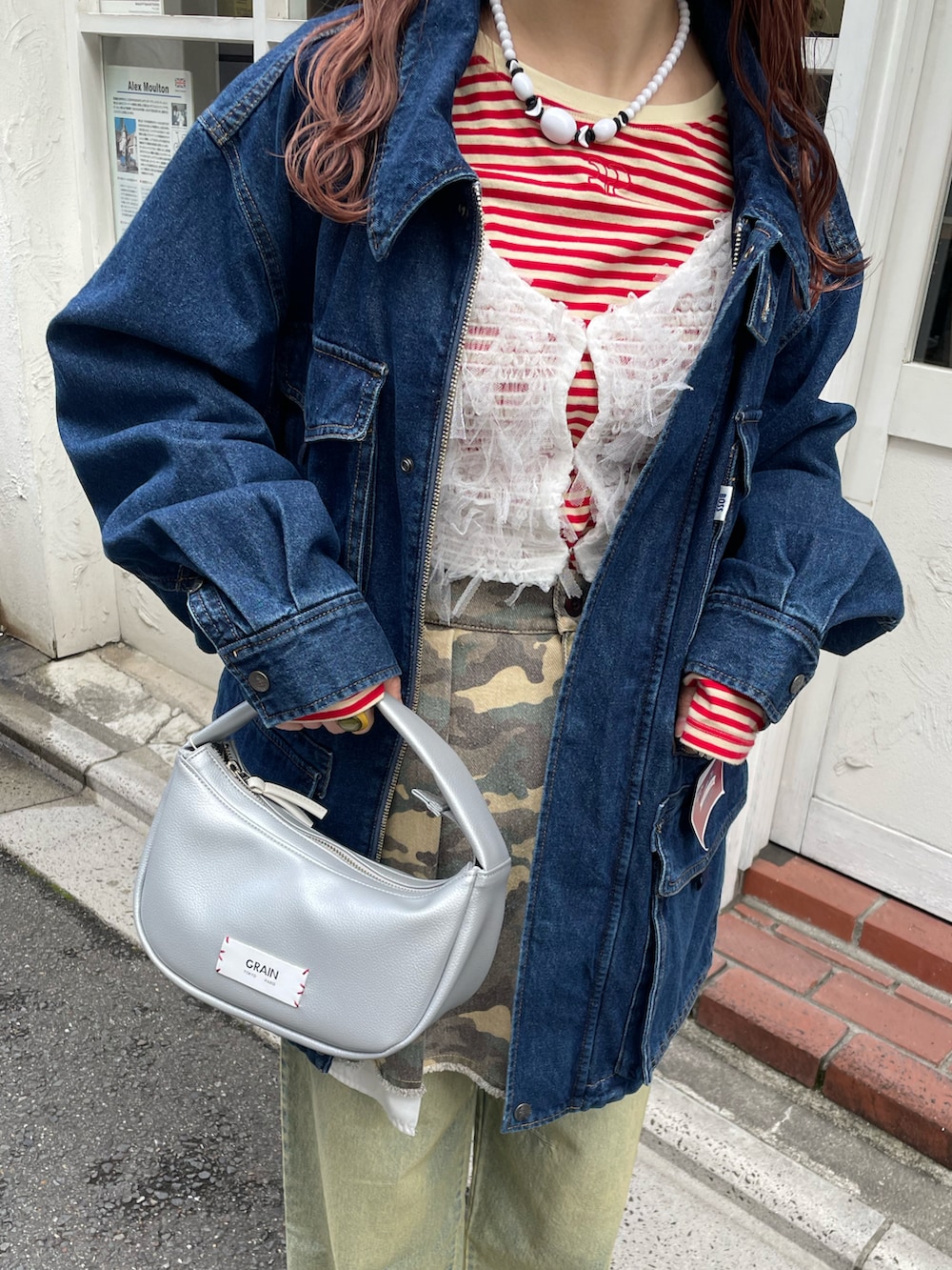 ブルー系のカバーオール、レッド系のTシャツ/カットソー、ホワイト系のキャミソールを着用したレディースの春コーディネートの4枚目の写真