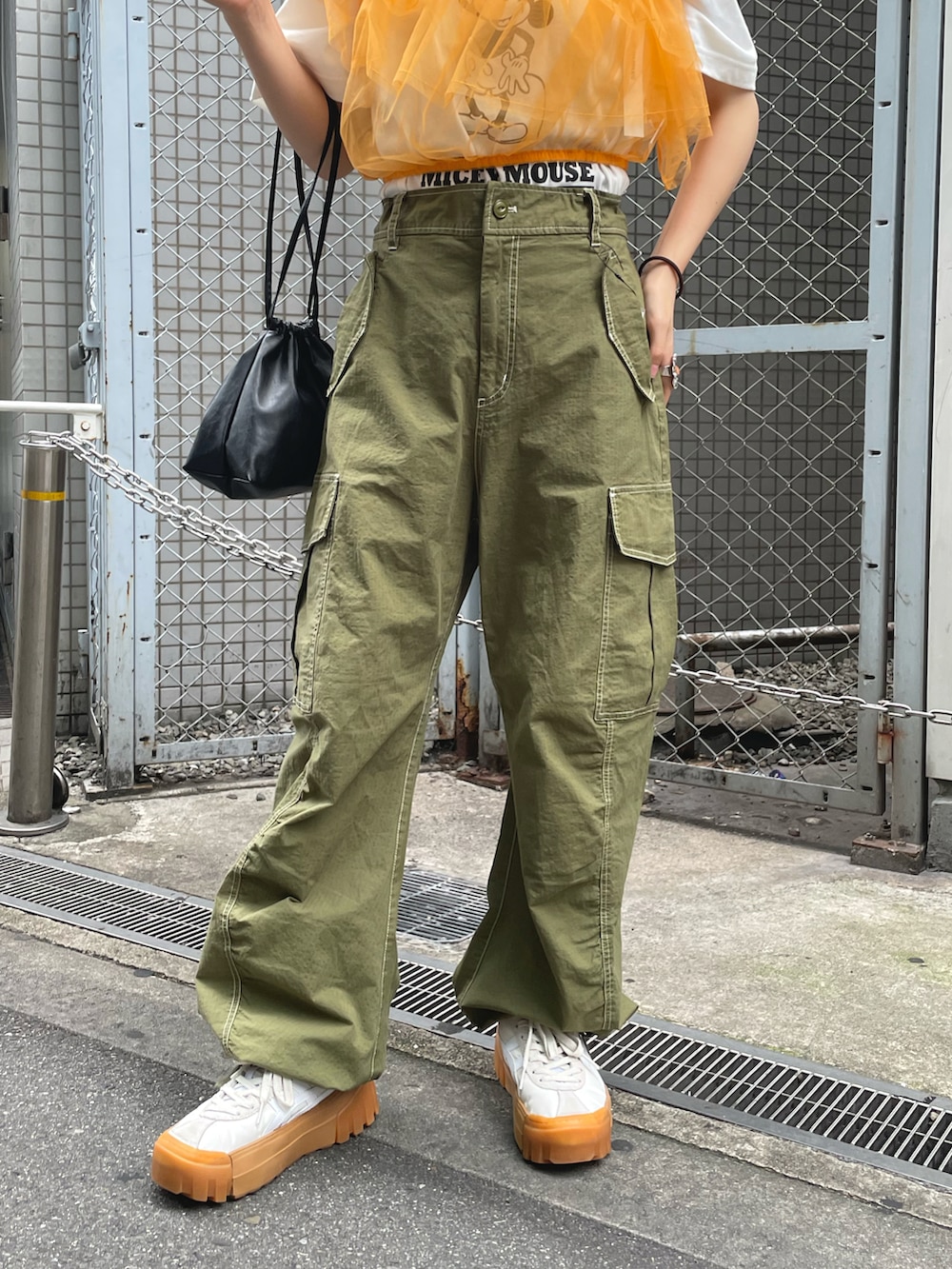 「夏コーデ、Tシャツ、白Tシャツ、オレンジ、オレンジコーデ、カラーコーデ、チュール、ビスチェ、カーゴパンツ、カーキ、巾着バッグ、ディズニーコーデ、レイヤードスタイル」|「CIAOPANICのワンショルダーチュールビスチェ(その他トップス、オレンジ系)」を使った、丸尾佳奈さん(レディース・158cm)の夏コーディネートの5枚目の写真