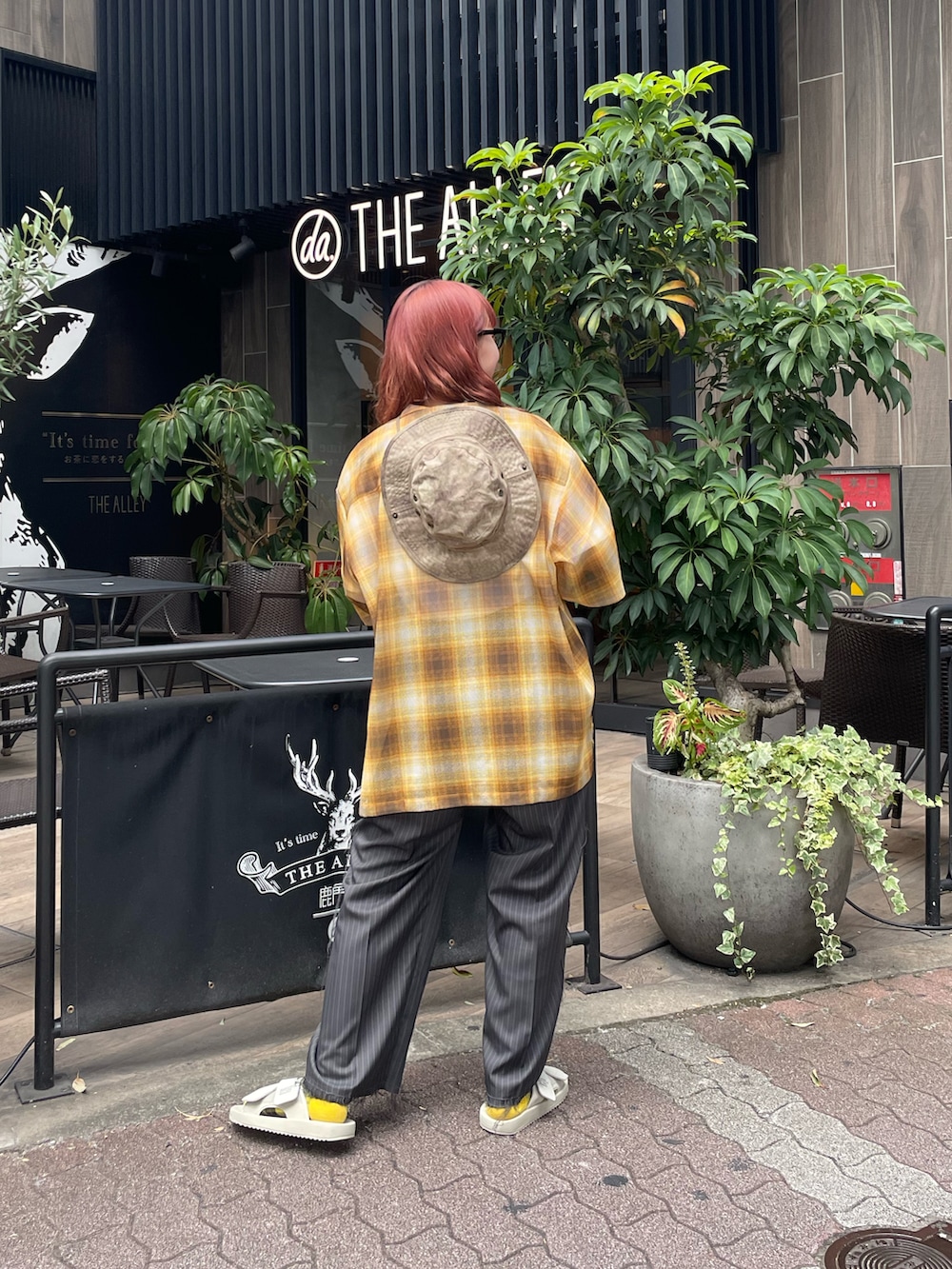 ホワイト系のTシャツ/カットソー、イエロー系のシャツ/ブラウス、グレー系のスラックスを着用したレディースの夏コーディネートの2枚目の写真