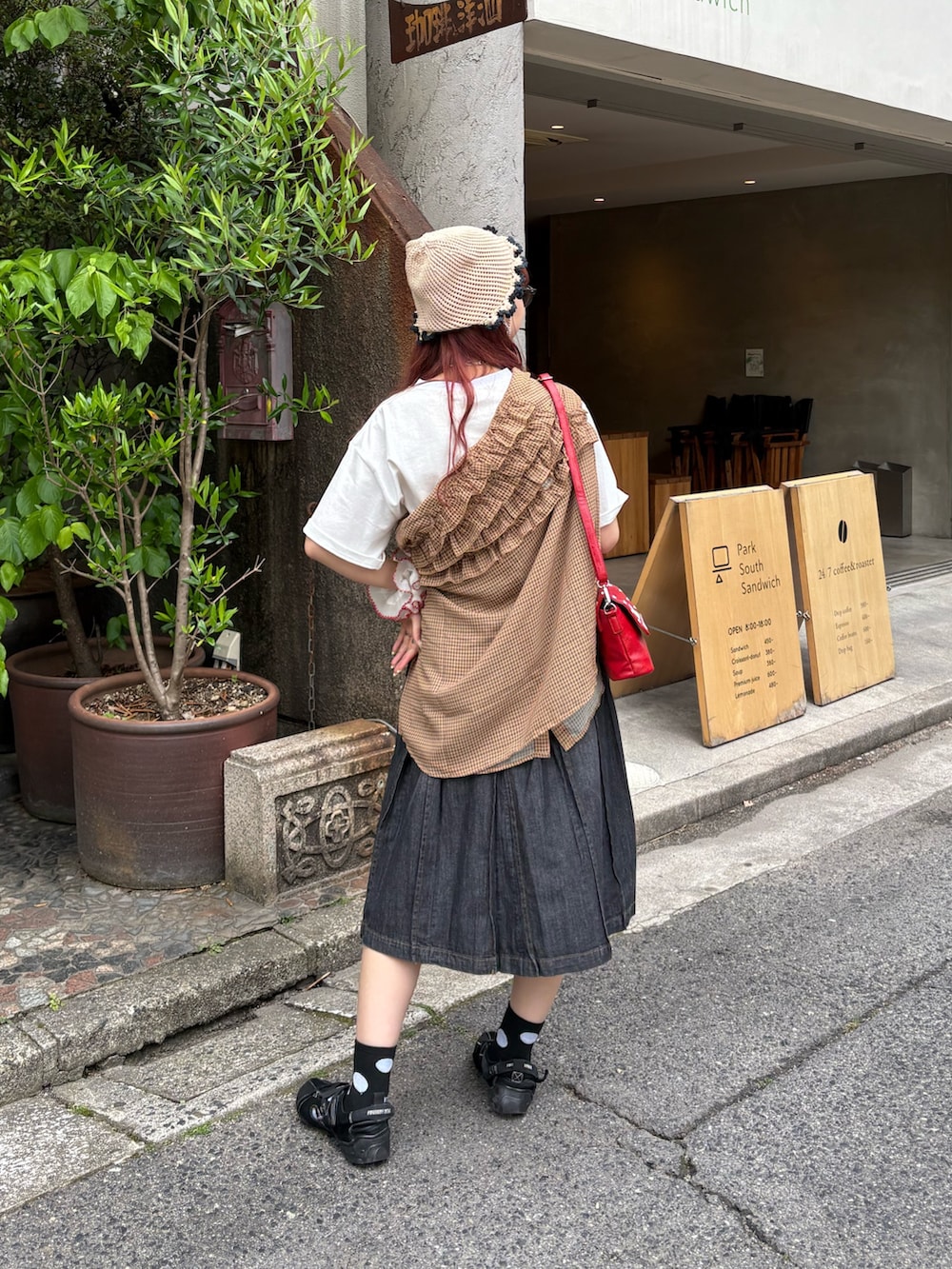 ブラック系のデニムスカート、イエロー系のシャツ/ブラウス、ホワイト系のTシャツ/カットソーを着用したレディースの夏コーディネートの3枚目の写真