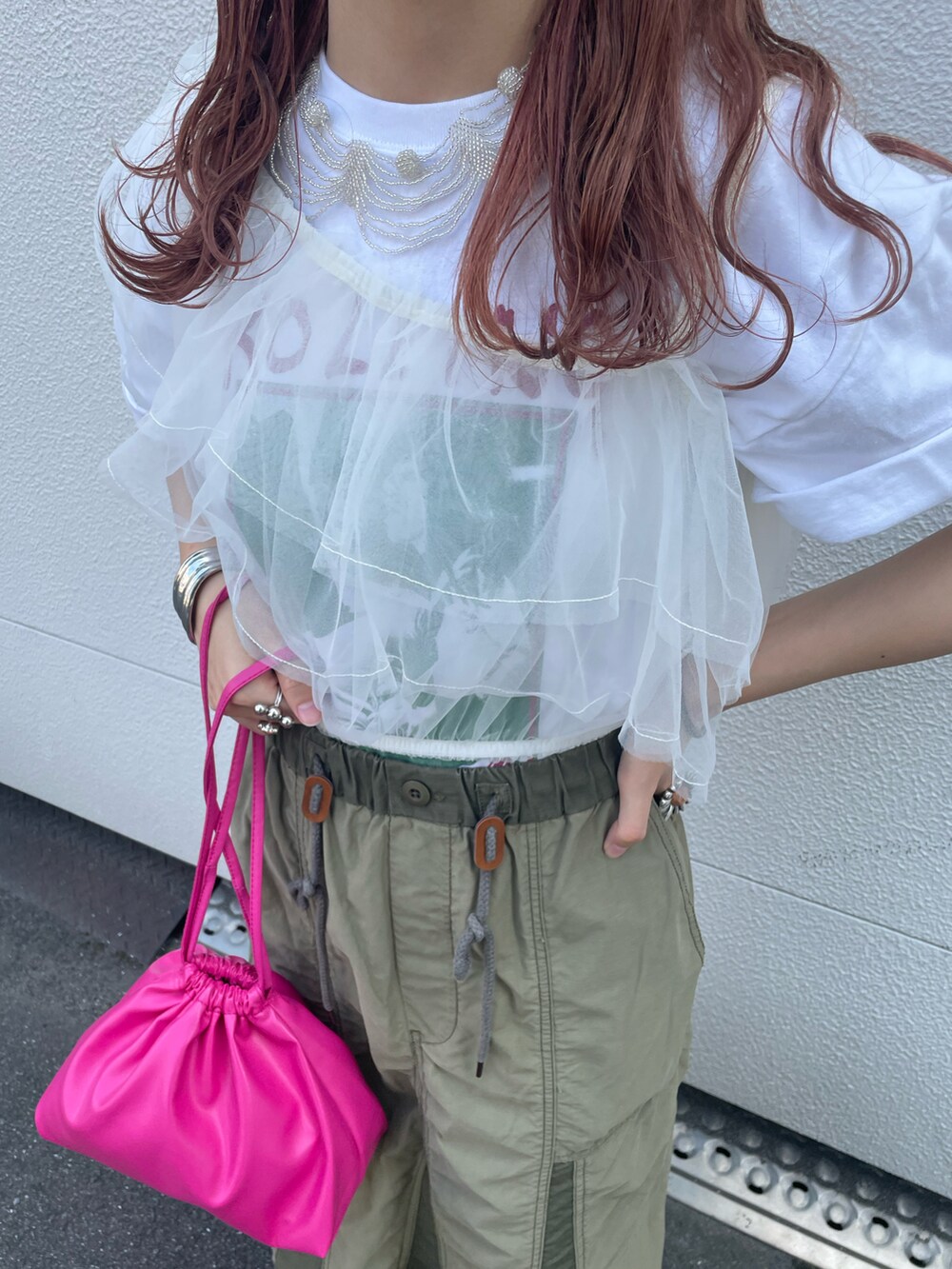 ピンク系のショルダーバッグ、グリーン系のスカート、ホワイト系のその他トップスを着用したレディースの夏コーディネートの4枚目の写真