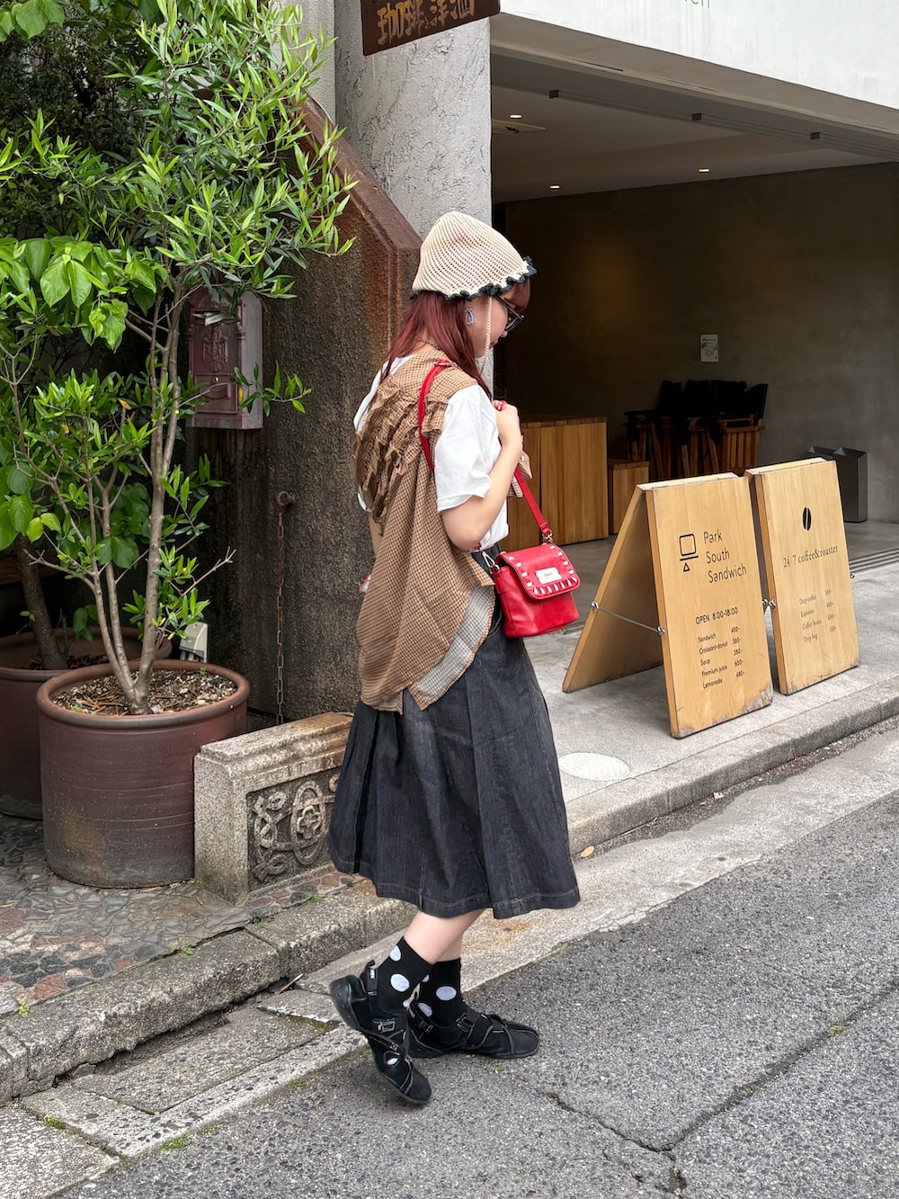 ブラック系のデニムスカート、イエロー系のシャツ/ブラウス、ホワイト系のTシャツ/カットソーを着用したレディースの夏コーディネートの2枚目の写真