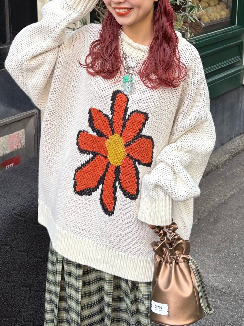 グリーン系のスカート、ゴールド系のハンドバッグを着用したレディースの冬コーディネートの2枚目の写真