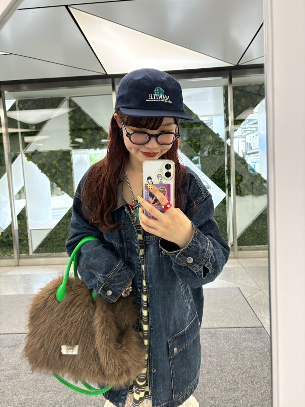 ブルー系のブルゾン、イエロー系のチュニック、ブラウン系のトートバッグを着用したレディースの秋コーディネートの2枚目の写真