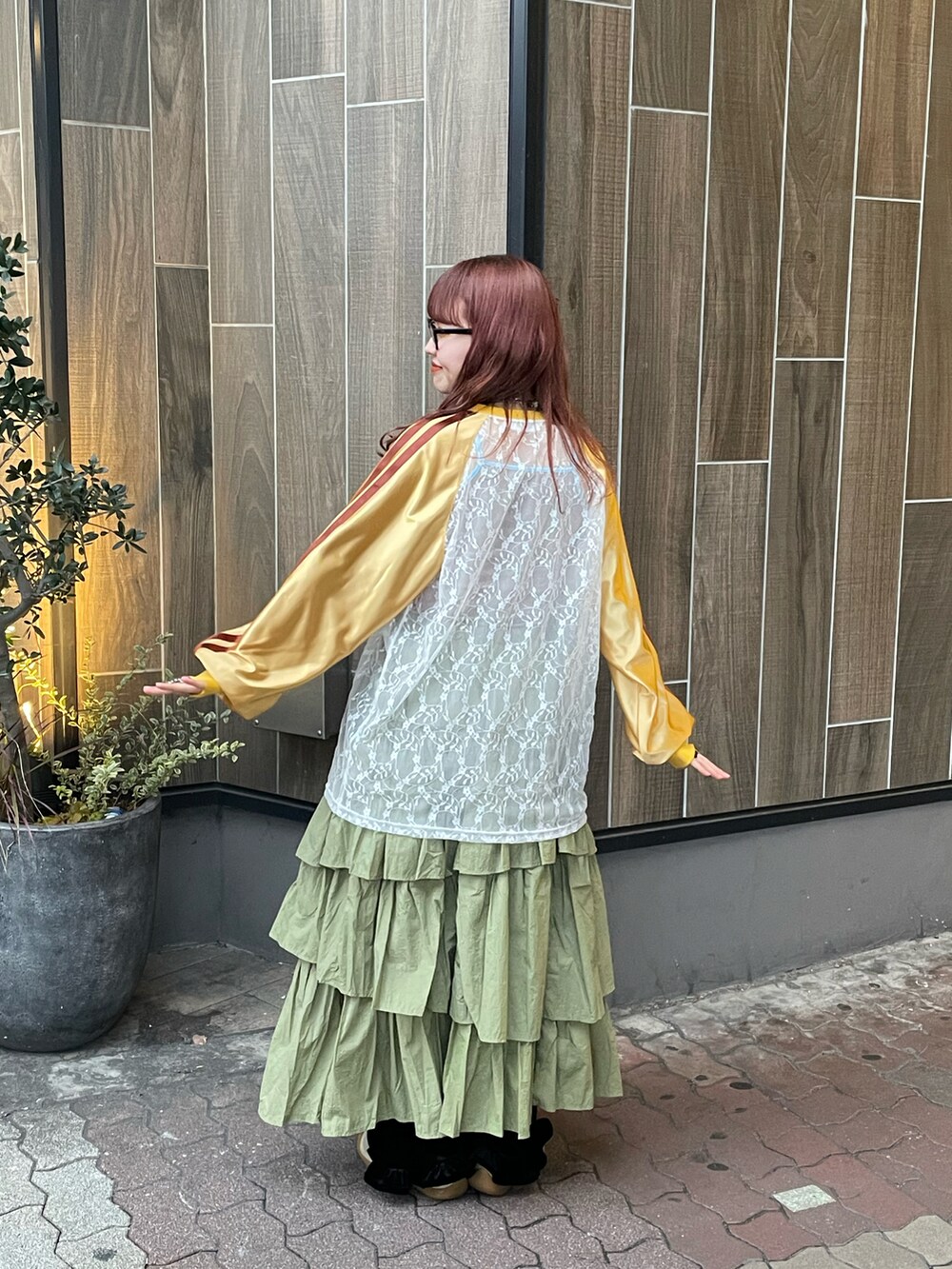 グリーン系のスカート、イエロー系のTシャツ/カットソーを着用したレディースの冬コーディネートの3枚目の写真