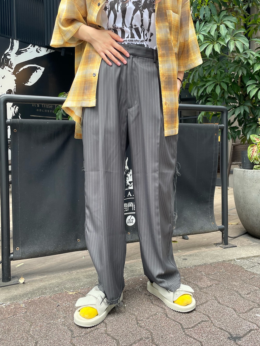 ホワイト系のTシャツ/カットソー、イエロー系のシャツ/ブラウス、グレー系のスラックスを着用したレディースの夏コーディネートの5枚目の写真