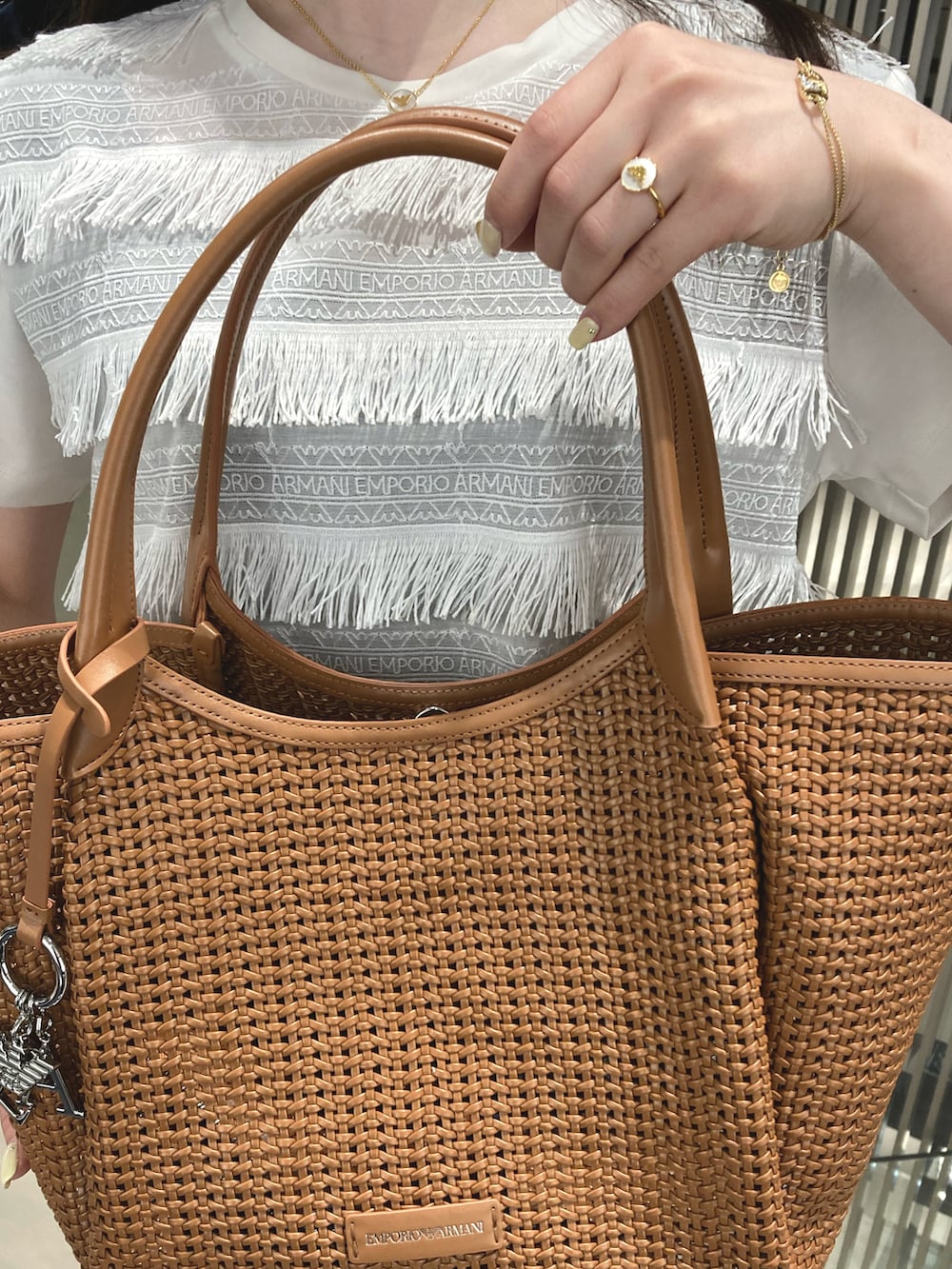 ホワイト系のTシャツ/カットソー、ブルー系のデニムパンツ、ブラウン系のトートバッグを着用したレディースの夏コーディネートの2枚目の写真