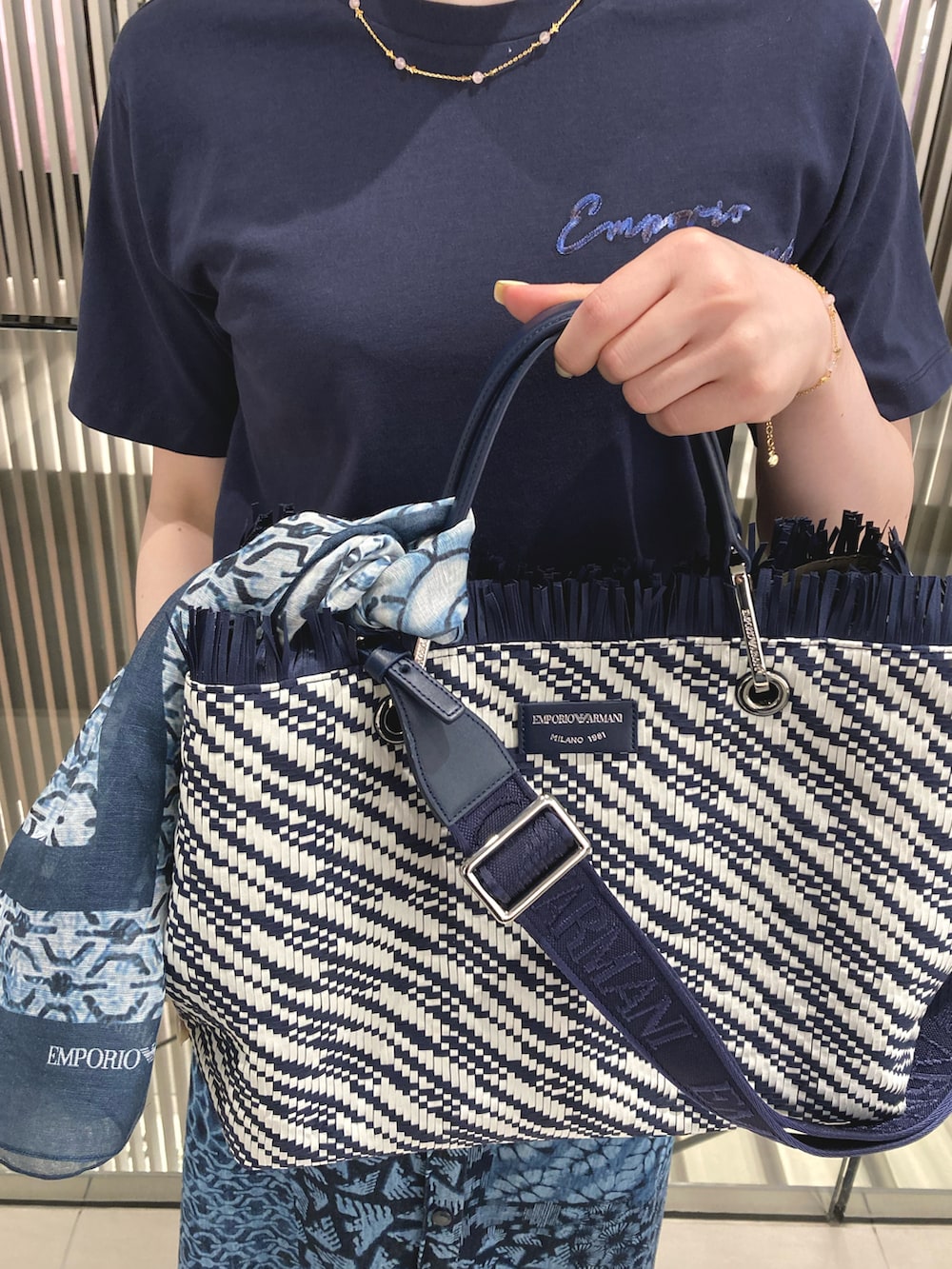 ブルー系のTシャツ/カットソー、ブルー系のスカート、ブルー系のトートバッグを着用したレディースの夏コーディネートの2枚目の写真