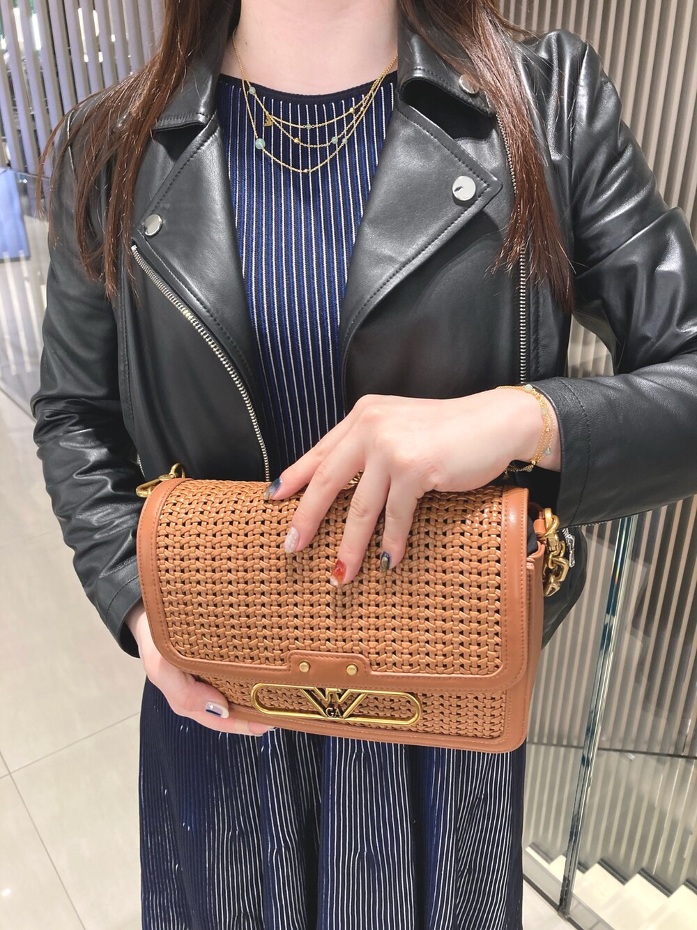 ブラック系のワンピース、ゴールド系のネックレス、ゴールド系のブレスレットを着用したレディースの夏コーディネートの2枚目の写真