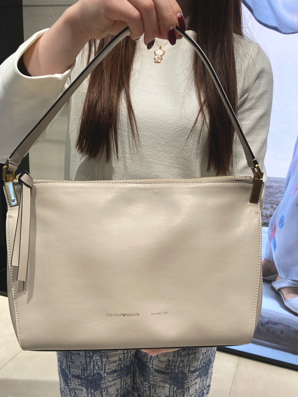 ブルー系のショルダーバッグ、ホワイト系のニット/セーター、ブルー系のその他パンツを着用したレディースの冬コーディネートの4枚目の写真