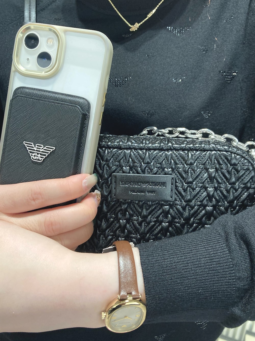 ブラック系のニット/セーター、ブラック系のショルダーバッグ、ブラウン系のアナログ腕時計を着用したレディースの秋コーディネートの2枚目の写真