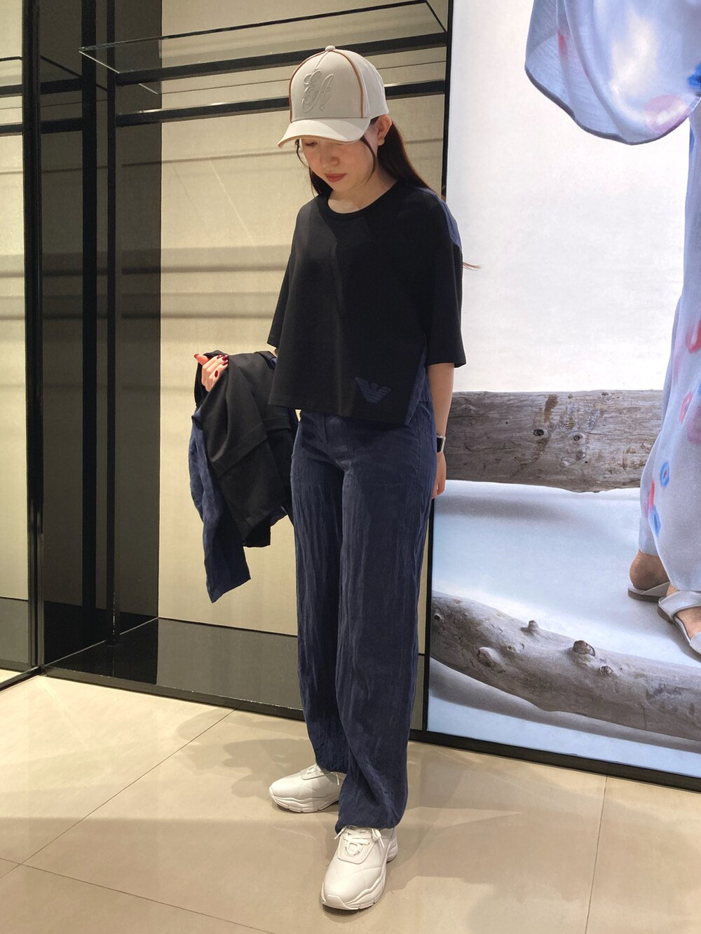 ブラック系のブルゾン、ブラック系のTシャツ/カットソー、ホワイト系のスニーカーを着用したレディースの冬コーディネートの2枚目の写真