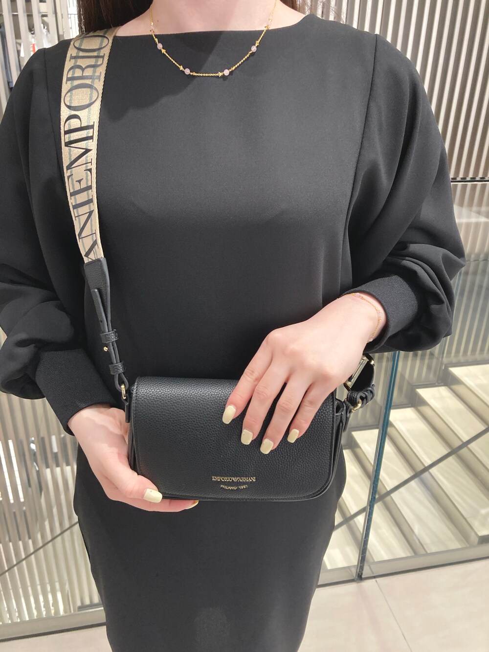 ブラック系のドレス、ブラック系のショルダーバッグ、ホワイト系のソックス/靴下を着用したレディースの夏コーディネートの2枚目の写真