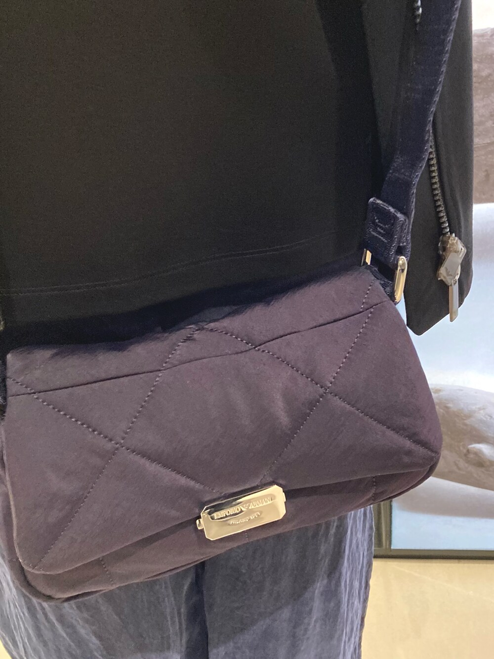 ブラック系のブルゾン、ブラック系のTシャツ/カットソー、ホワイト系のスニーカーを着用したレディースの冬コーディネートの5枚目の写真