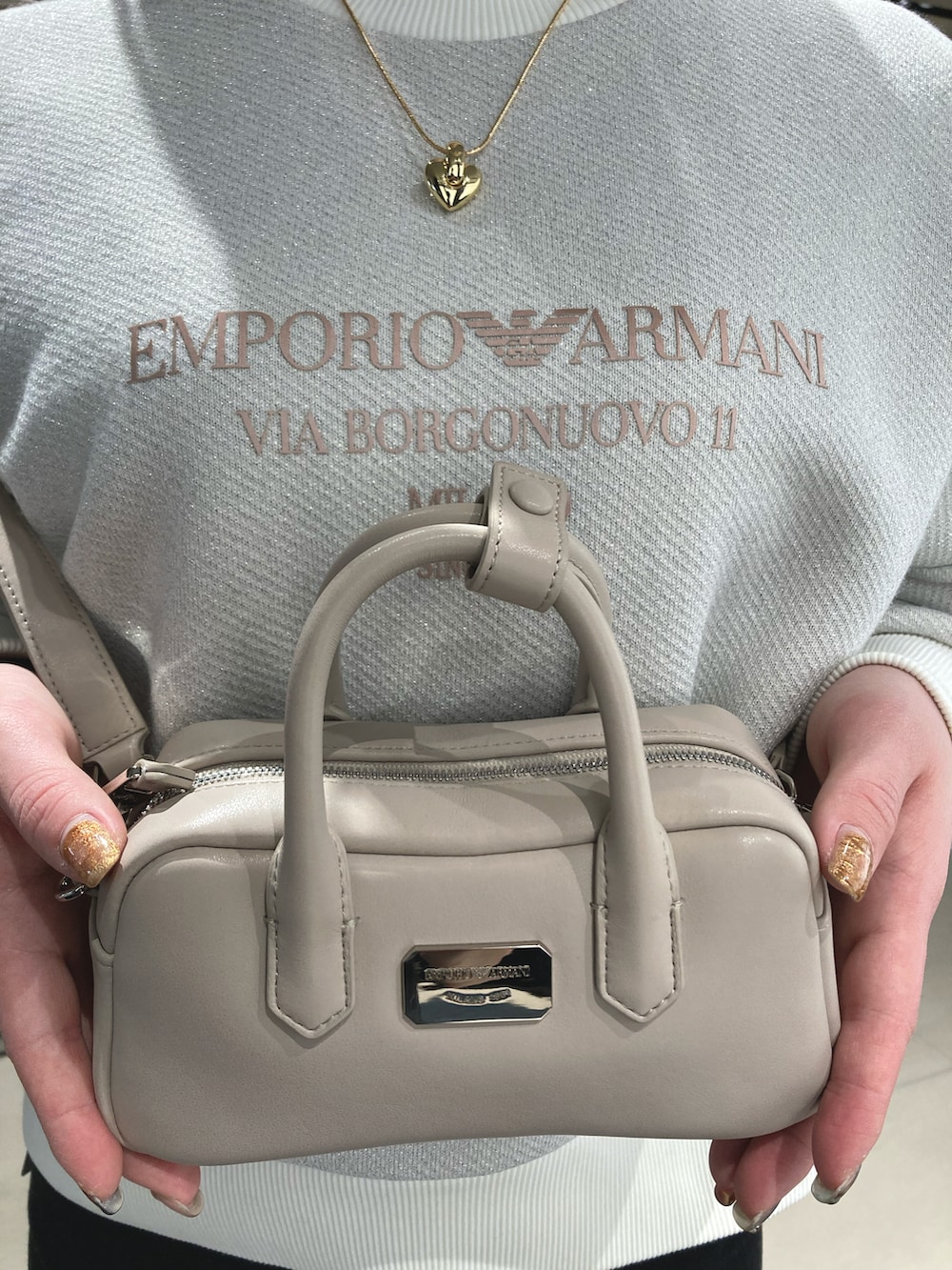 ホワイト系のスウェット、ゴールド系のネックレス、シルバー系のピアス（両耳用）を着用したレディースの冬コーディネートの2枚目の写真