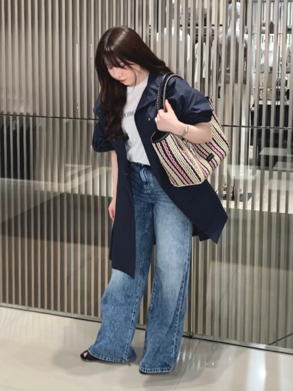 ホワイト系のTシャツ/カットソー、ブルー系のトレンチコート、ブルー系のデニムパンツを着用したレディースの春コーディネートの2枚目の写真