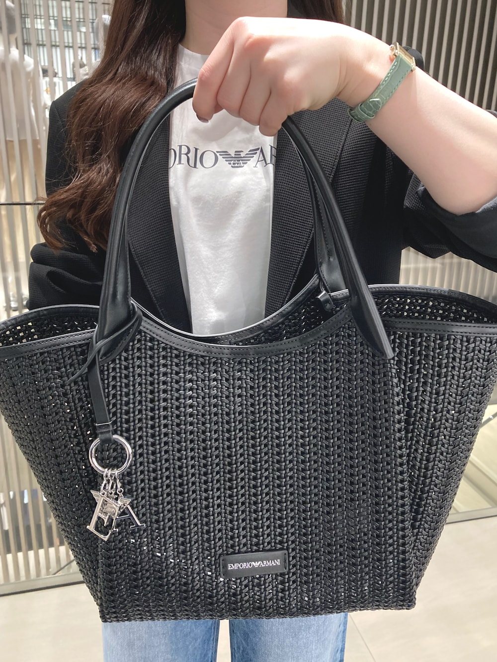 ブラック系のテーラードジャケット、ホワイト系のTシャツ/カットソー、ブルー系のデニムパンツを着用したレディースの春コーディネートの2枚目の写真