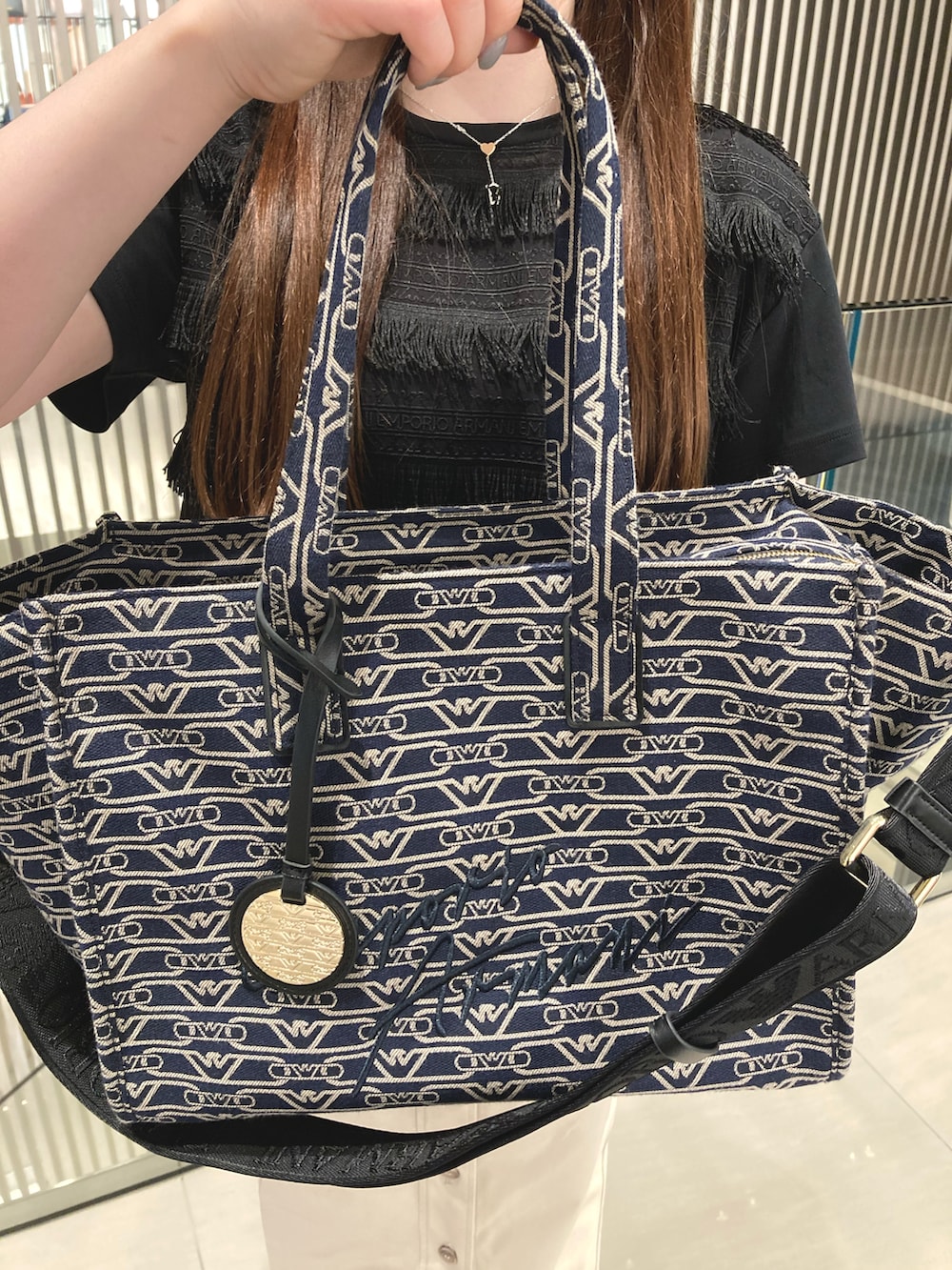ブルー系のトートバッグ、ホワイト系のTシャツ/カットソー、ベージュ系のスカートを着用したレディースの冬コーディネートの3枚目の写真