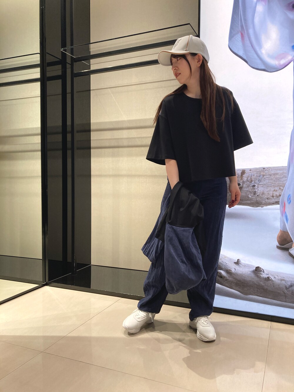 ブラック系のブルゾン、ブラック系のTシャツ/カットソー、ホワイト系のスニーカーを着用したレディースの冬コーディネートの3枚目の写真