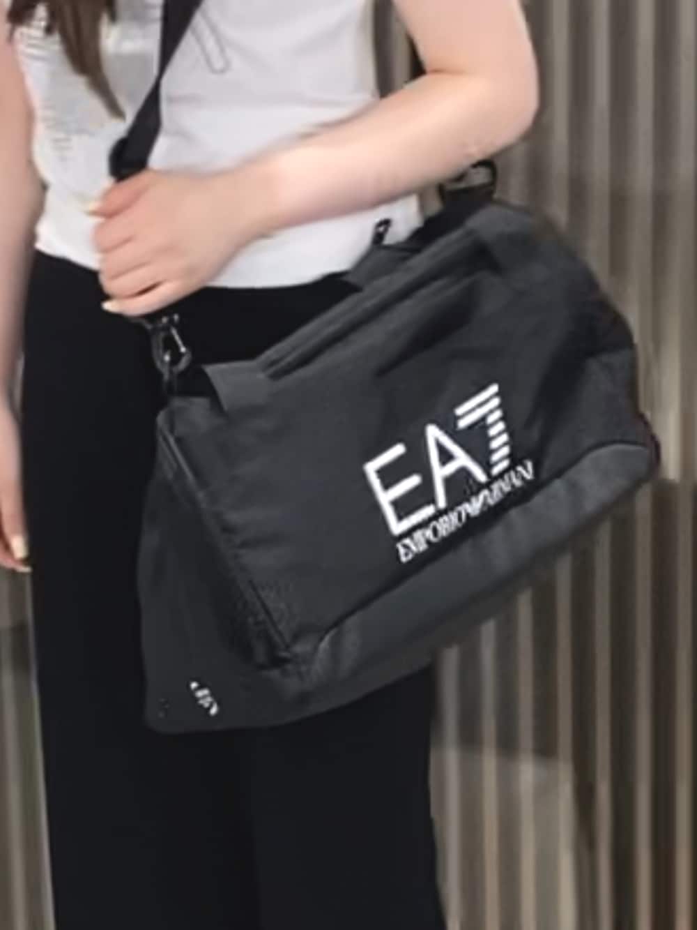 ホワイト系のTシャツ/カットソー、ブラック系のドラムバッグ、ブラック系のその他パンツを着用したレディースの春コーディネートの2枚目の写真