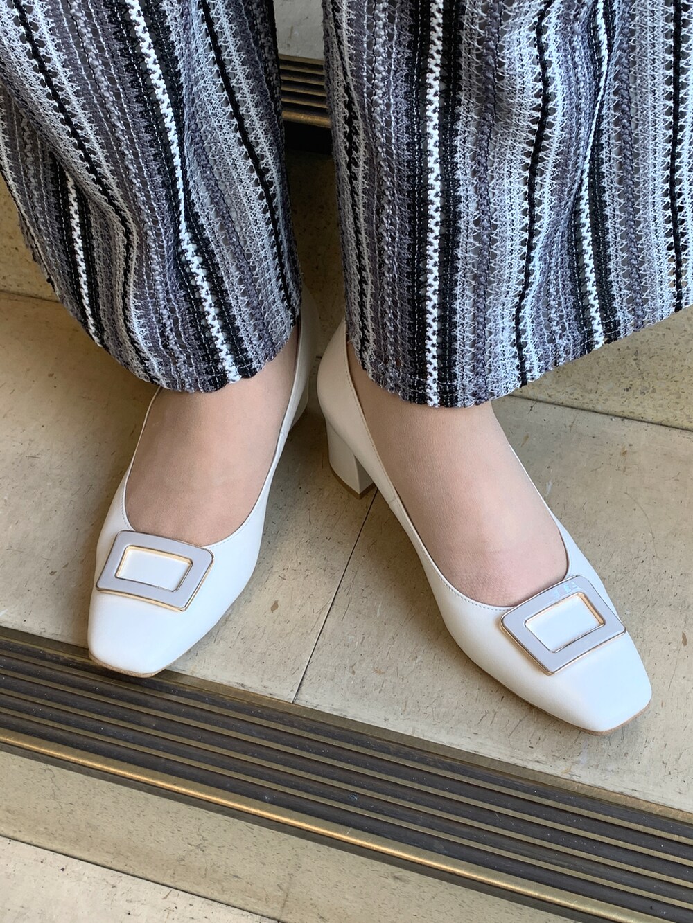 ホワイト系のパンプスを着用したレディースの春コーディネートの2枚目の写真