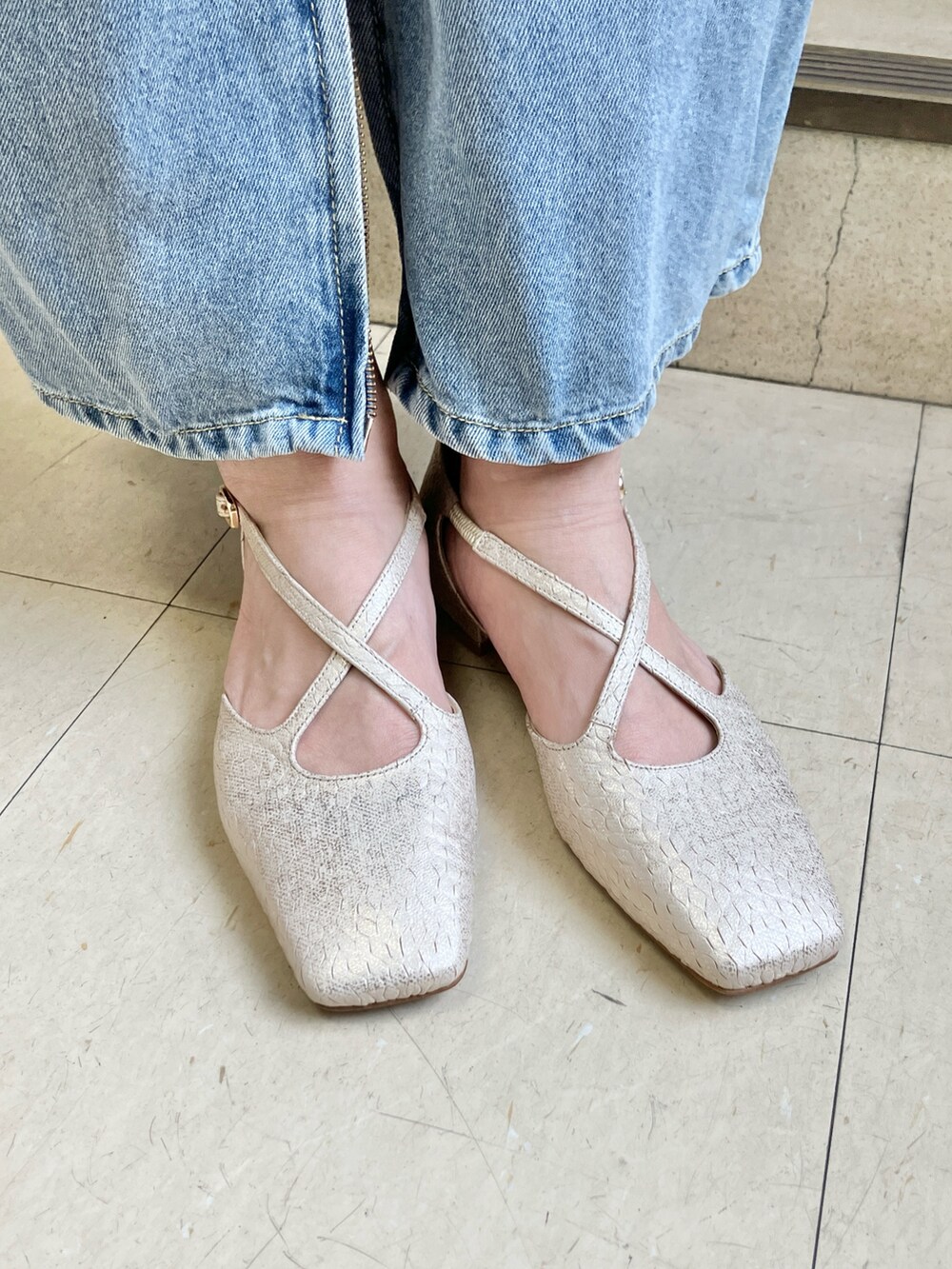 ゴールド系のパンプスを着用したレディースの春コーディネートの2枚目の写真