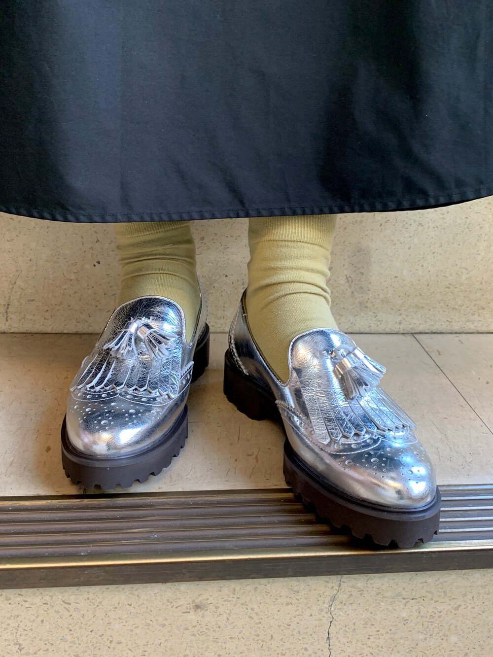 シルバー系のローファーを着用したレディースの春コーディネートの2枚目の写真