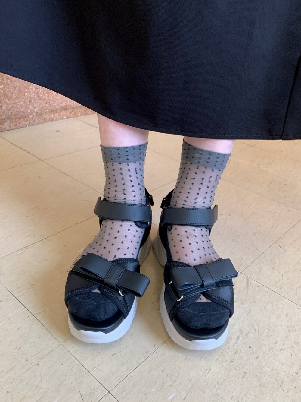 ブラック系のサンダル、ホワイト系のショルダーバッグを着用したレディースの春コーディネートの2枚目の写真