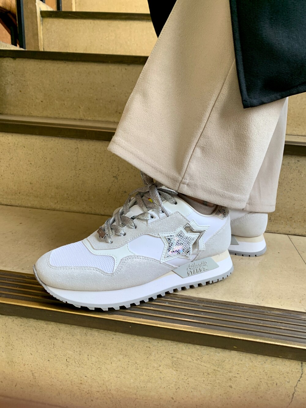 シルバー系のスニーカーを着用したレディースの春コーディネートの2枚目の写真