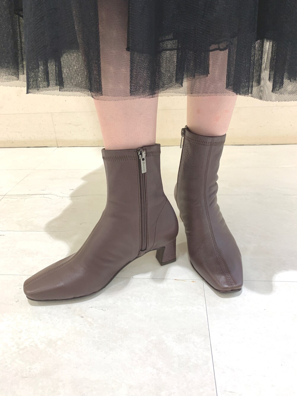 ブラウン系のブーツを着用したレディースの秋コーディネートの2枚目の写真