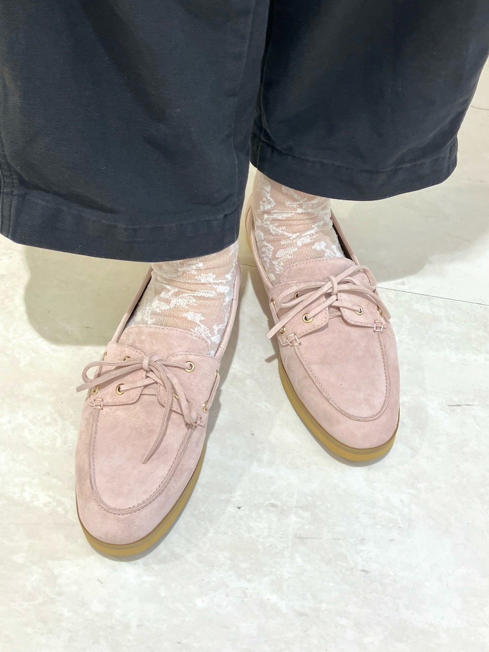 ピンク系のパンプス、ブラウン系のショルダーバッグを着用したレディースの春コーディネートの2枚目の写真
