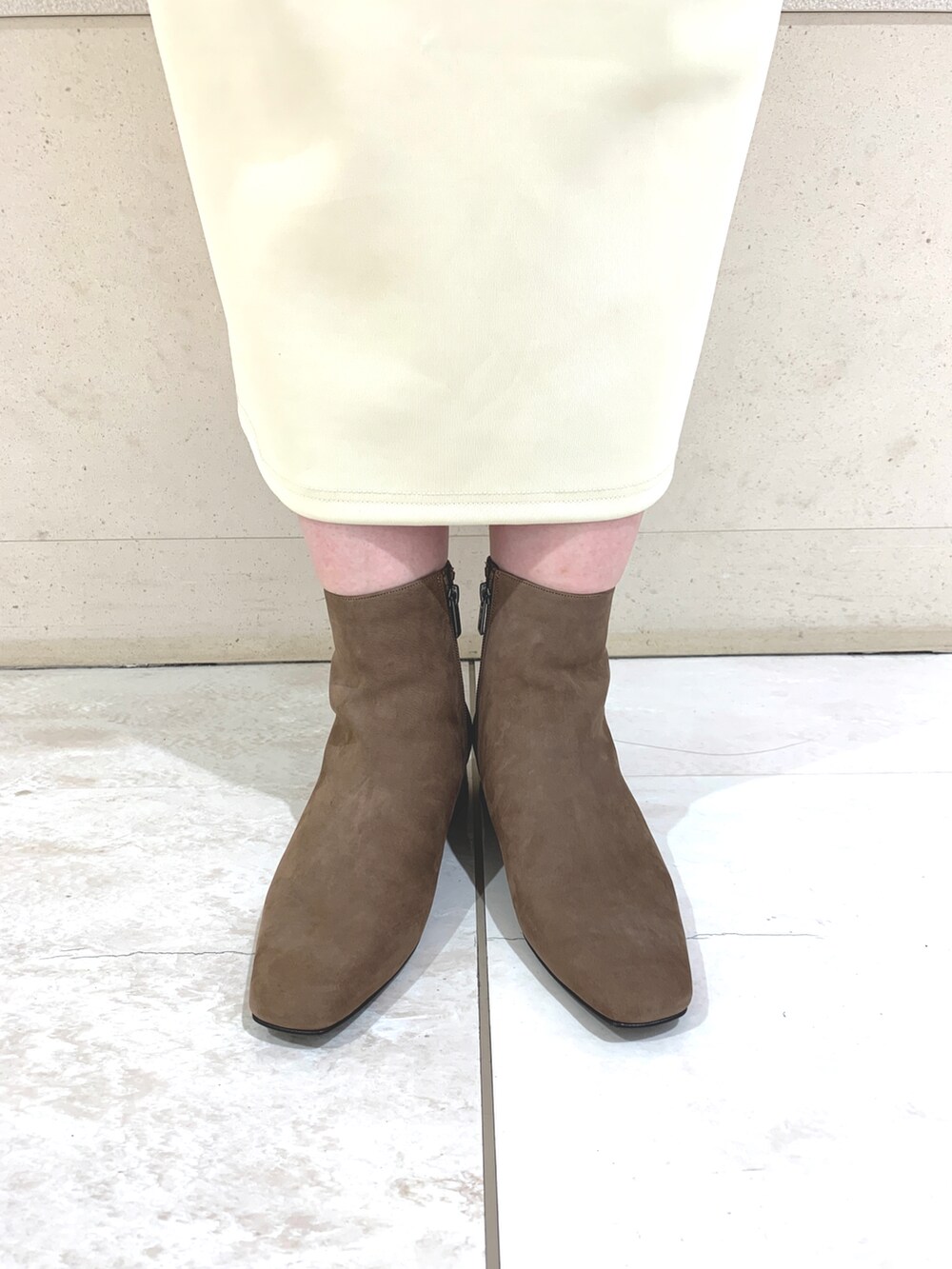 ベージュ系のブーツを着用したレディースの秋コーディネートの2枚目の写真