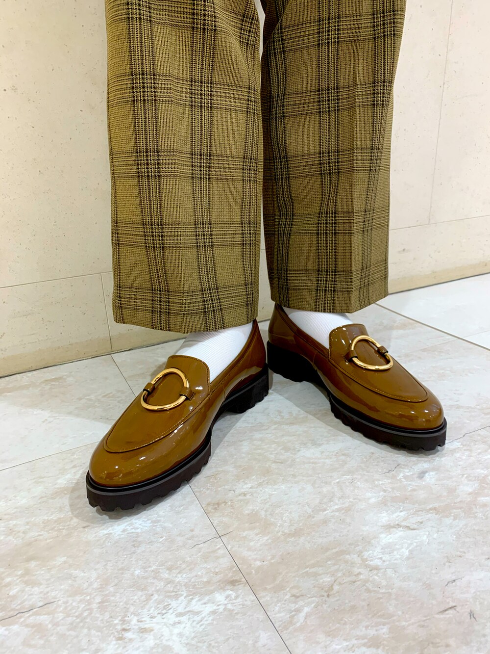 ブラウン系のローファーを着用したレディースの秋コーディネートの2枚目の写真