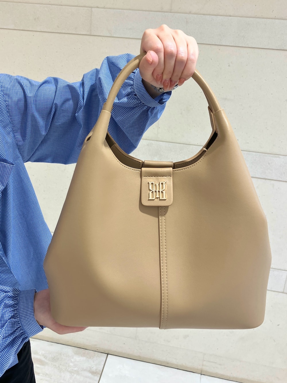 ピンク系のパンプス、ブラウン系のショルダーバッグを着用したレディースの春コーディネートの3枚目の写真