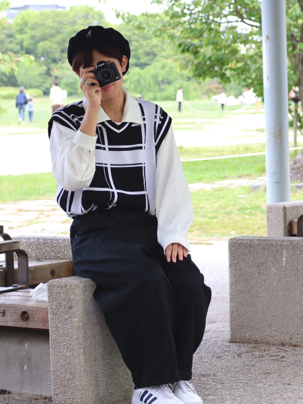 ブラック系のベスト、ブラック系のその他パンツ、ホワイト系のスニーカーを着用したメンズの春コーディネートの2枚目の写真