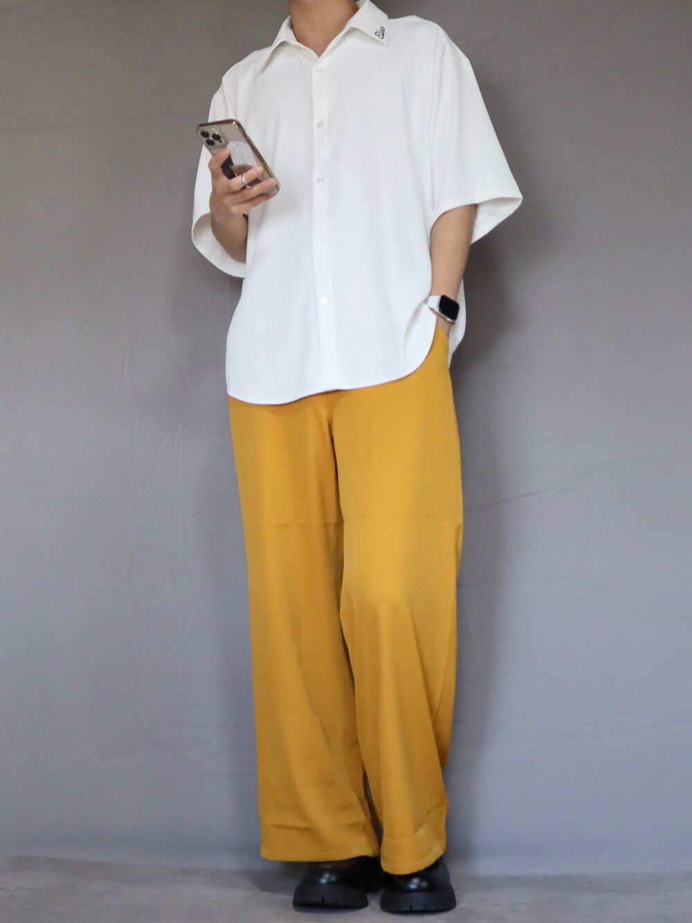 ホワイト系のシャツ/ブラウス、イエロー系のその他パンツ、ブラック系のブーツを着用したメンズの春コーディネートの2枚目の写真