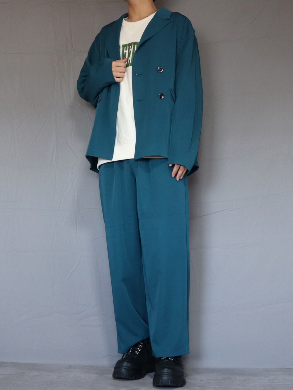 ブルー系のテーラードジャケット、ホワイト系のトップス、ブルー系のスラックスを着用したメンズの春コーディネートの2枚目の写真