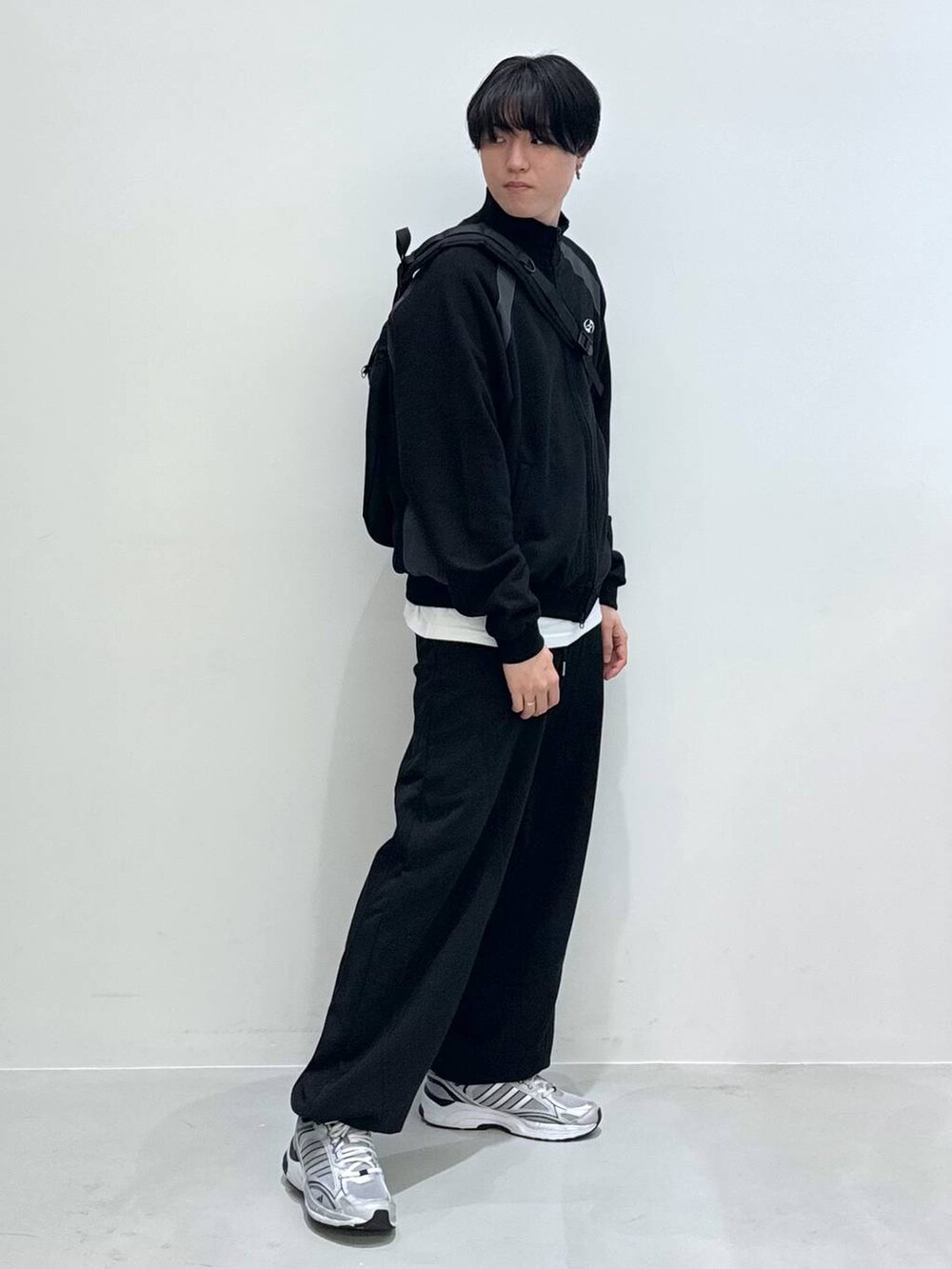 ブラック系のバックパック/リュック、ブラック系のスウェットパンツ、ホワイト系のTシャツ/カットソーを着用したメンズの冬コーディネートの5枚目の写真