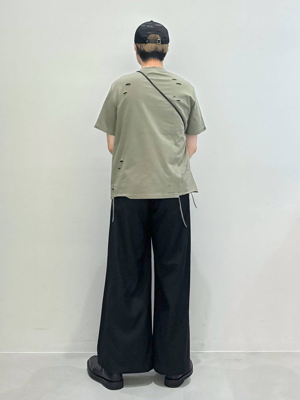 ブラック系のブーツ、ブラック系のショルダーバッグ、ブラック系のスラックスを着用したメンズの夏コーディネートの3枚目の写真