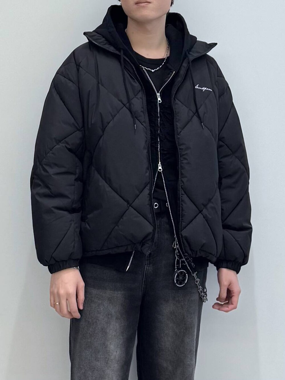 ブラック系のダウンジャケット/コート、ブラック系のデニムパンツ、ブラック系のパーカーを着用したメンズの冬コーディネートの2枚目の写真