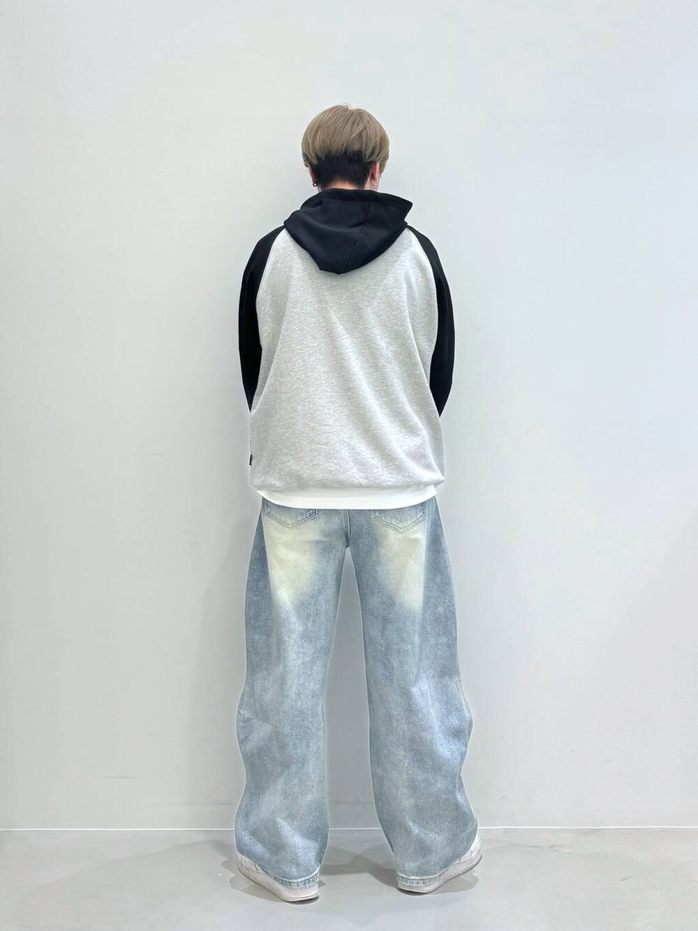 ブルー系のデニムパンツ、ブラック系のパーカーを着用したメンズの春コーディネートの3枚目の写真