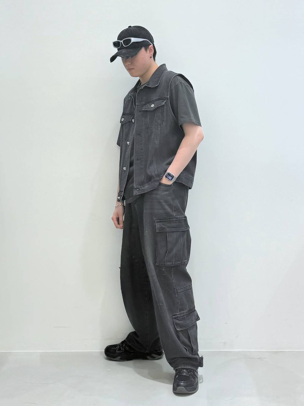 ブラック系のデニムパンツ、ブラック系のベスト、グレー系のTシャツ/カットソーを着用したメンズの春コーディネートの3枚目の写真