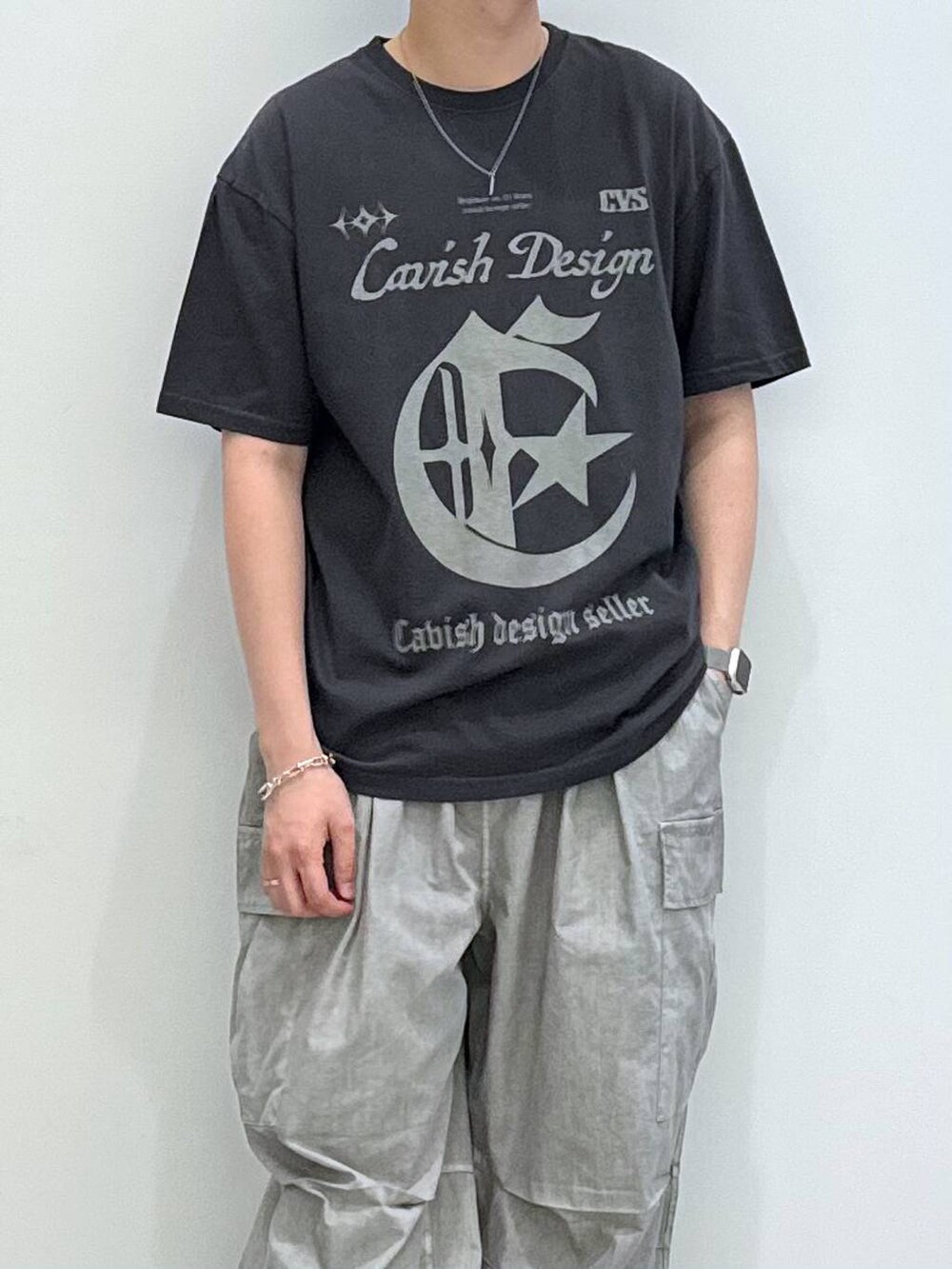 グレー系のTシャツ/カットソー、グレー系のキャップ、ブラック系のサングラスを着用したメンズの夏コーディネートの2枚目の写真