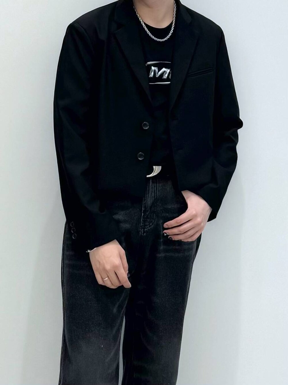 ブラック系のTシャツ/カットソー、ブラック系のテーラードジャケット、ブラック系のデニムパンツを着用したメンズの春コーディネートの2枚目の写真