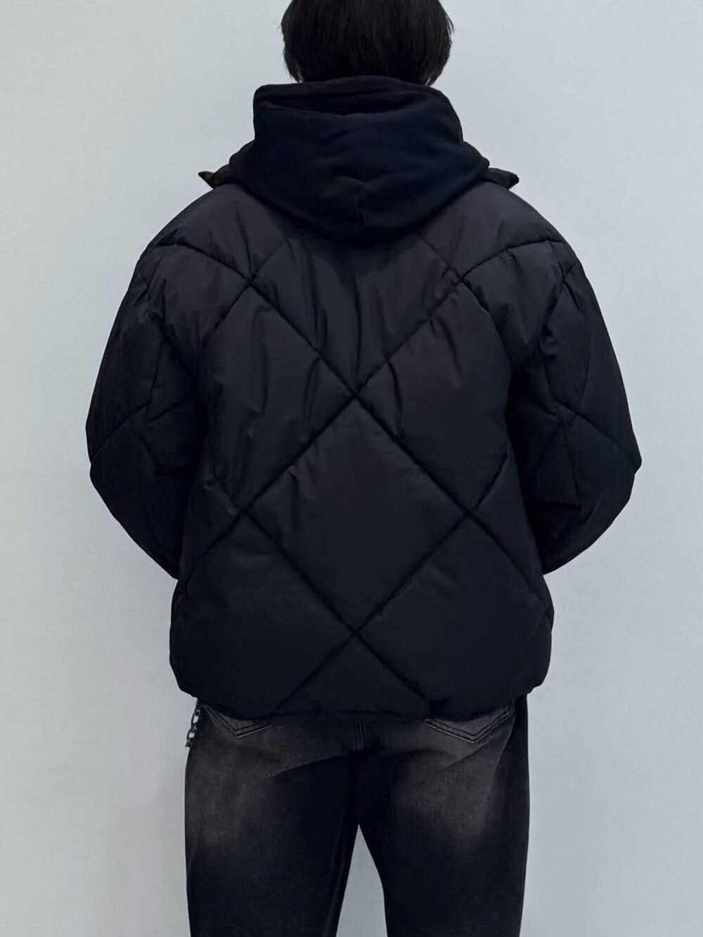 ブラック系のダウンジャケット/コート、ブラック系のデニムパンツ、ブラック系のパーカーを着用したメンズの冬コーディネートの5枚目の写真