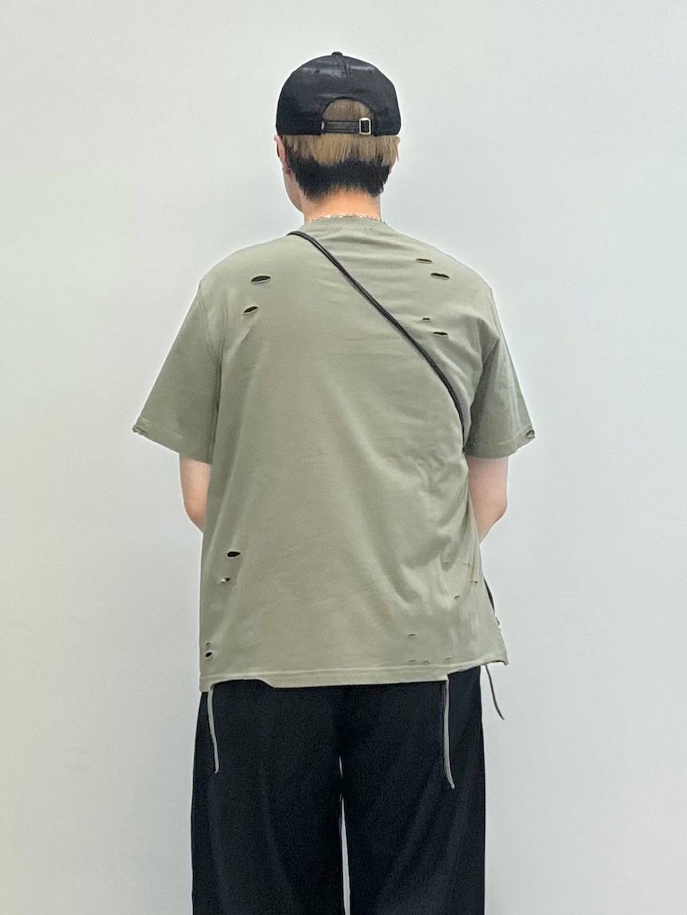 ブラック系のブーツ、ブラック系のショルダーバッグ、ブラック系のスラックスを着用したメンズの夏コーディネートの4枚目の写真