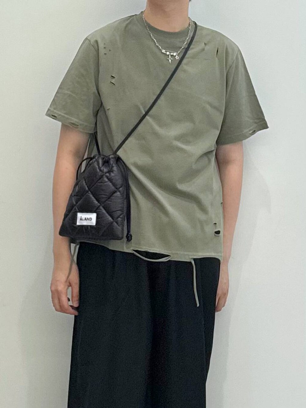 ブラック系のブーツ、ブラック系のショルダーバッグ、ブラック系のスラックスを着用したメンズの夏コーディネートの2枚目の写真